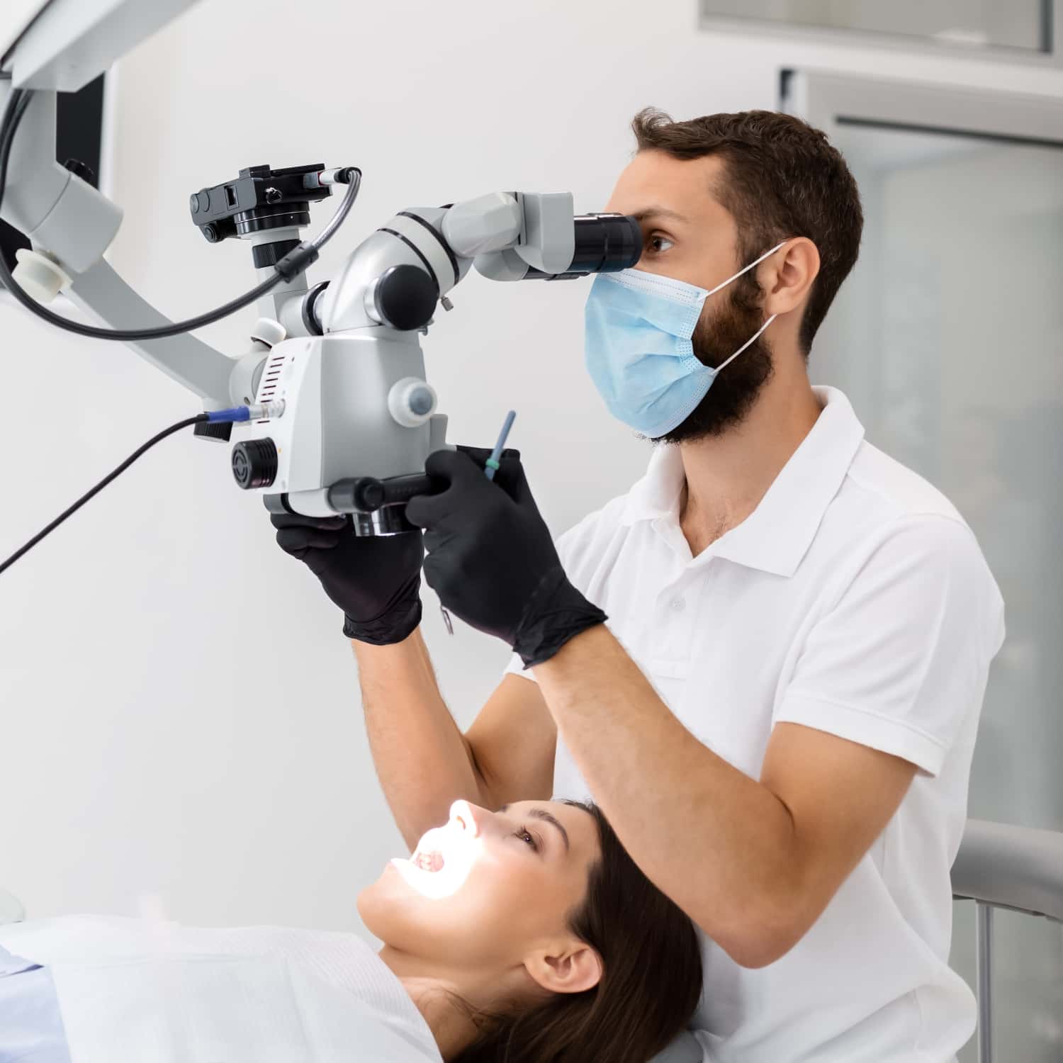Dentist using a dental microscope during patient care